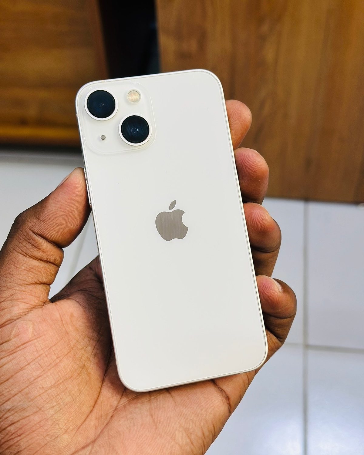 White iPhone 13 mini in hand - Legacy Luxury Store Ghana