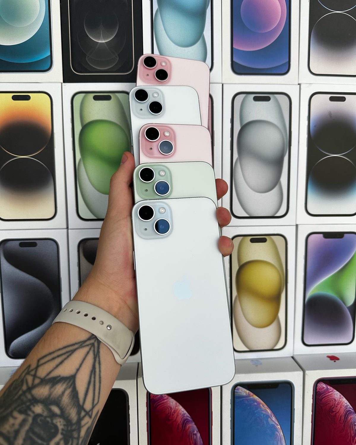 iPhone 15 Plus colours stacked in hand - Legacy Luxury Store Ghana